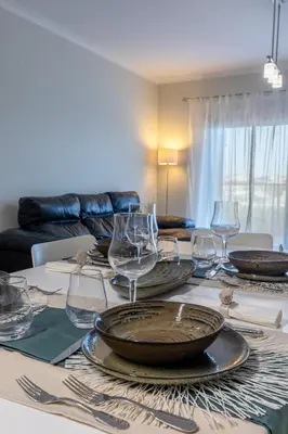 a table with plates and wine glasses on it at Apartamento 7 Mares in Sagres