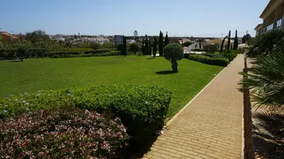 a brick walkway through a park with a grass field at Apartamento 7 Mares in Sagres