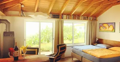 a bedroom with a bed and a table with chairs at Quinta dos Artistas in Santa Cruz