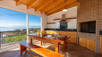 a kitchen with a table and a large window at Casa Del Sol by LovelyStay in Relógio do Poiso