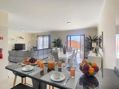 a living room with a table with fruit on it at Casa Mes Amis by LovelyStay in Relógio do Poiso
