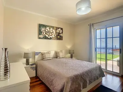 a bedroom with a bed and a large window at Casa Mes Amis by LovelyStay in Relógio do Poiso