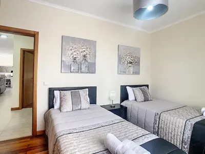 two beds in a room with white walls at Casa Mes Amis by LovelyStay in Relógio do Poiso
