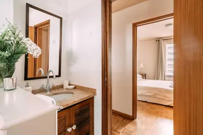 a bathroom with a sink and a mirror and a bed at Atlantic View Penthouse in Funchal