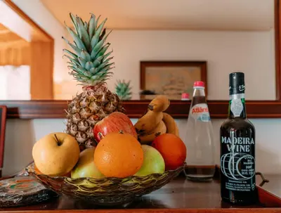 a bowl of fruit on a table next to a bottle of wine at Atlantic View Penthouse in Funchal