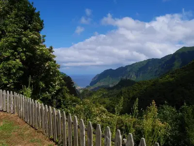 a wooden fence with a view of mountains at Casinhas da Laurissilva in São Vicente
