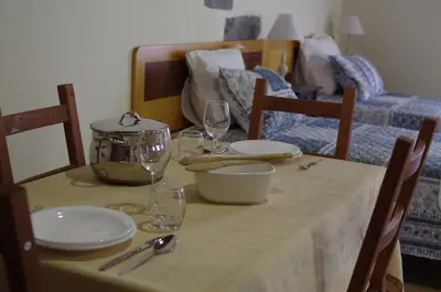 a table with plates and wine glasses on top of it at Casinhas da Laurissilva in São Vicente