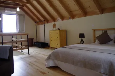 a bedroom with a large bed and a window at Casinhas da Laurissilva in São Vicente