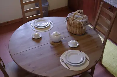 a wooden table with plates and a tea pot on it at Casinhas da Laurissilva in São Vicente