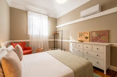 a bedroom with a bed and a dresser and a chair at The Wine Lodges by An Island Apart in Funchal