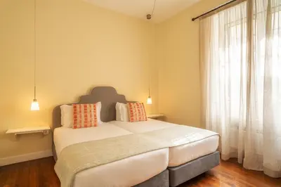 a bedroom with a bed and a large window at The Wine Lodges by An Island Apart in Funchal
