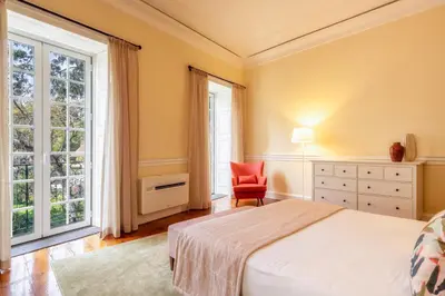 a bedroom with a bed and a chair and a window at The Wine Lodges by An Island Apart in Funchal