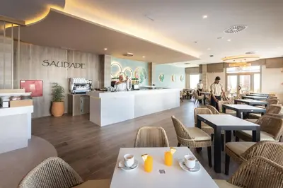a restaurant with tables and chairs and a counter at Hotel Riu Madeira - All Inclusive in Caniço