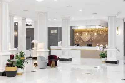 a lobby with a bar and chairs in a building at Hotel Riu Madeira - All Inclusive in Caniço