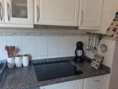 a kitchen with white cabinets and a black counter top at Apartamento Marques in Santa Cruz