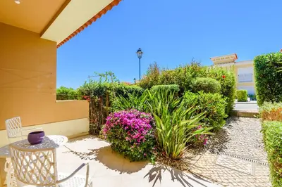 a patio with a table and chairs and flowers at Casa Mapie - Boavista Resort in Lagos