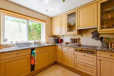 a kitchen with wooden cabinets and a window at Casa Mapie - Boavista Resort in Lagos