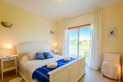 a bedroom with a bed and a large window at Casa Mapie - Boavista Resort in Lagos