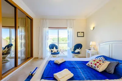 a bedroom with a blue bed and a balcony at Casa Mapie - Boavista Resort in Lagos