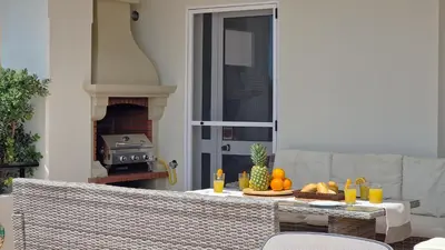 a patio with a hot tub and chairs in front of a house at Casa Ulli by LovelyStay in Caniço