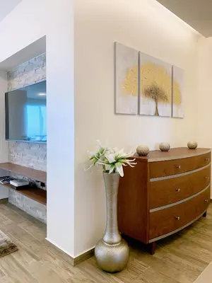 a living room with a vase with flowers in it at Holiday Apartment Sunset Ocean in Ribeira Brava