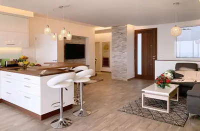 a kitchen and living room with a table and a couch at Holiday Apartment Sunset Ocean in Ribeira Brava