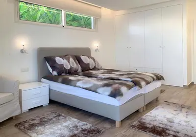 a bedroom with a bed and white cabinets at Holiday Apartment Sunset Ocean in Ribeira Brava