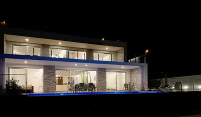 a house with a pool in front of it at night at Holiday Apartment Sunset Ocean in Ribeira Brava