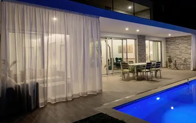 a house with a pool and a dining room with a table at Holiday Apartment Sunset Ocean in Ribeira Brava