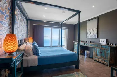a bedroom with a canopy bed and a window at Mansão Macau by LovelyStay in Arco da Calheta