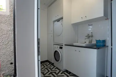 a laundry room with a washing machine and a sink at Mansão Macau by LovelyStay in Arco da Calheta