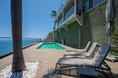 a group of chairs sitting next to a swimming pool at Mansão Macau by LovelyStay in Arco da Calheta