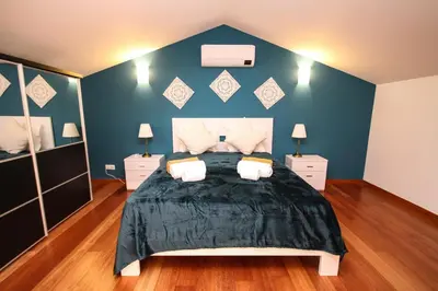 a bedroom with a large bed with blue walls at LUXURY APARTMENT - T1 vue sur piscine - PRAIA DA LUZ in Luz
