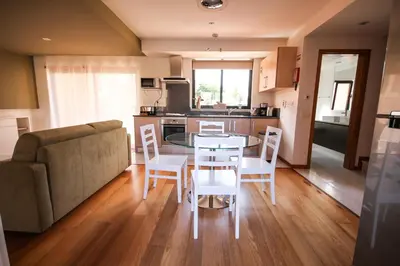 a kitchen and living room with a table and a couch at LUXURY APARTMENT - T1 vue sur piscine - PRAIA DA LUZ in Luz