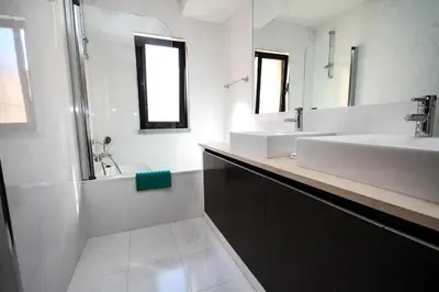 a bathroom with two sinks and a mirror and a tub at LUXURY APARTMENT - T1 vue sur piscine - PRAIA DA LUZ in Luz