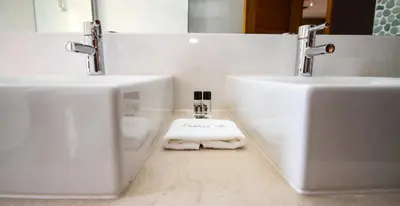 a bathroom with two sinks and two towels on the floor at LUXURY APARTMENT - T1 vue sur piscine - PRAIA DA LUZ in Luz