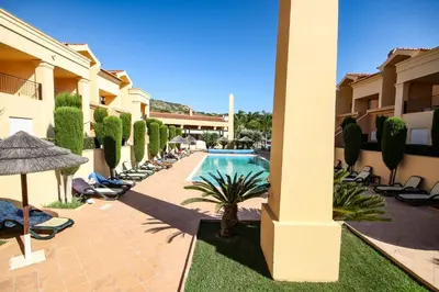 a view of the courtyard of a hotel with chairs and a swimming pool at LUXURY APARTMENT - T1 vue sur piscine - PRAIA DA LUZ in Luz