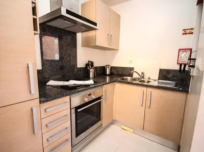 a small kitchen with a sink and a stove at LUXURY APARTMENT - T2 vue sur piscine - PRAIA DA LUZ in Luz