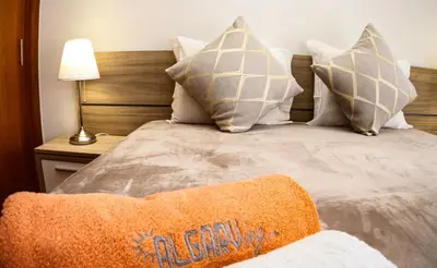 a bedroom with a bed with pillows and a lamp at LUXURY APARTMENT - T2 vue sur piscine - PRAIA DA LUZ in Luz
