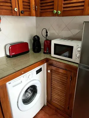 a kitchen with a washing machine and a microwave at Sea Light Seaview Vista Mar Apartment - Luz, Lagos in Luz
