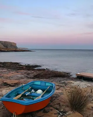 a blue and orange boat sitting on the beach at Sea Light Seaview Vista Mar Apartment - Luz, Lagos in Luz