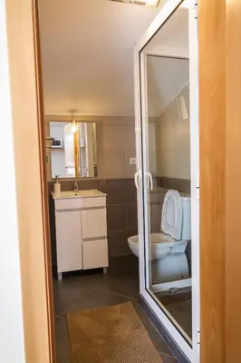 a bathroom with a toilet and a sink and a mirror at maktub sunset property in Paul do Mar