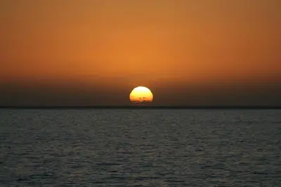 a sunset over the ocean with the sun in the horizon at maktub sunset property in Paul do Mar