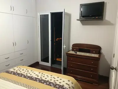 a bedroom with a bed and a dresser and a tv at Ammy’s House in Câmara de Lobos