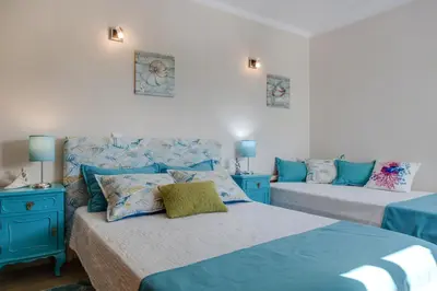 a bedroom with two beds and blue furniture at Refúgio Na Praia Da Luz in Luz