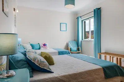 a bedroom with two beds and a window at Refúgio Na Praia Da Luz in Luz