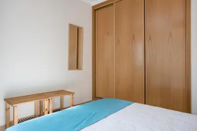 a bedroom with a bed and a wooden cabinet at Refúgio Na Praia Da Luz in Luz