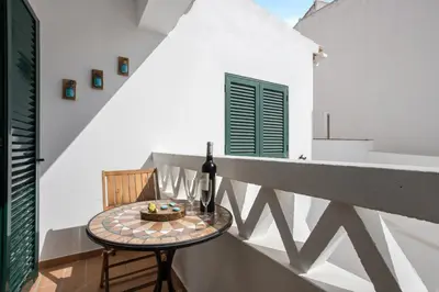 a table with a bottle of wine on a balcony at Refúgio Na Praia Da Luz in Luz