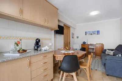 a kitchen and dining room with a table and a kitchen and a living room at Refúgio Na Praia Da Luz in Luz