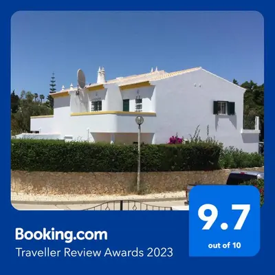 a white house with a sign that says travel review awards at Casa Rosa Floresta in Luz